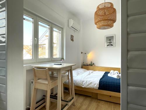 a bedroom with a bed and a table and a desk at Rooftop Studio In the heart of Bucharest w Netflix in Bucharest