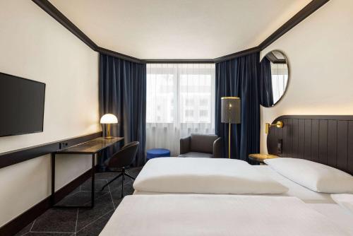 una camera d'albergo con due letti e una televisione di Vienna House by Wyndham Diplomat Prague a Praga