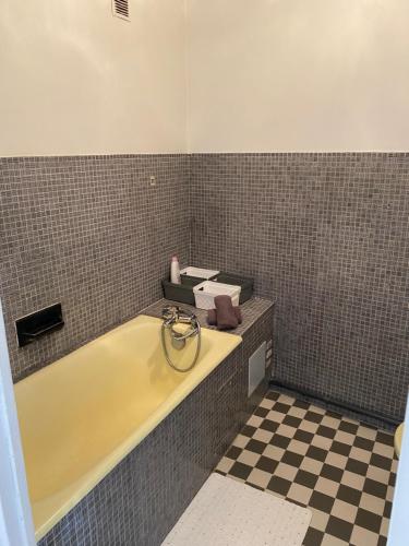 a bathroom with a tub and a checkerboard floor at Appartement calme Stade/plage in Marseille