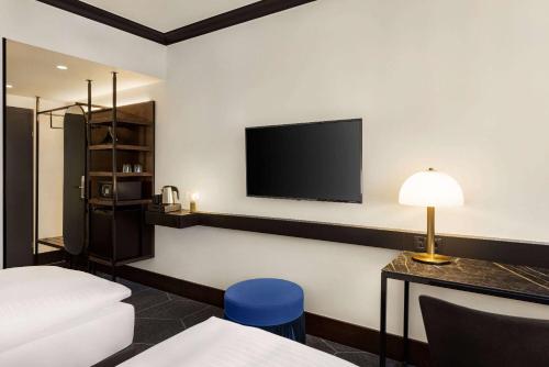 a hotel room with a bed and a tv on the wall at Vienna House by Wyndham Diplomat Prague in Prague