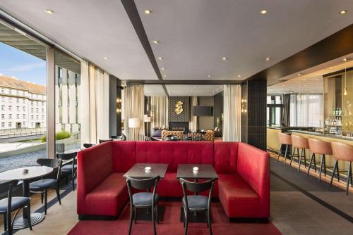a living room with a red couch and a table at Vienna House by Wyndham Diplomat Prague in Prague