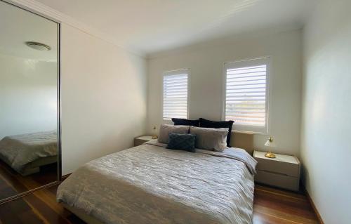 a bedroom with a large bed and a mirror at 4 bedroom family home in Riverwood in Riverwood