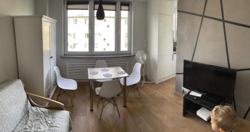 a living room with a table and chairs and a television at Apartament Centrum Malbork in Malbork