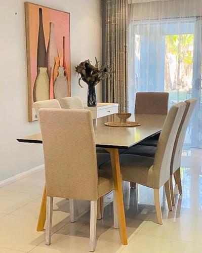 a dining room with a table and chairs at 4 bedroom family home in Riverwood in Riverwood