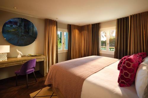 a bedroom with a bed and a desk and windows at Boho Club in Marbella