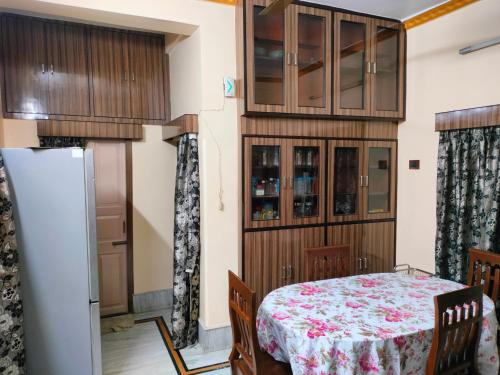 a dining room with a table and cabinets at Kanan Villa in Kolkata