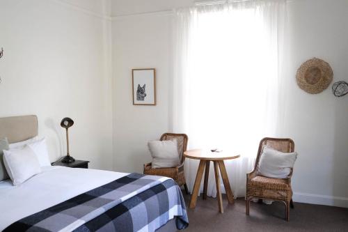 a bedroom with a bed and two chairs and a table at Flash Jacks of Gundagai in Gundagai