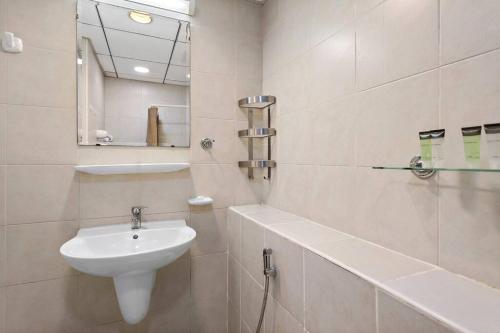 a white bathroom with a sink and a mirror at StoneTree - Elegant Studio in Peaceful Community in Dubai