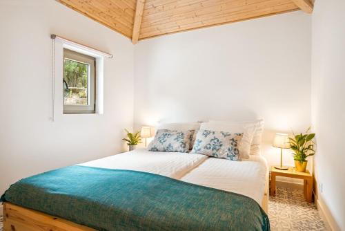 Schlafzimmer mit einem Bett und einem Fenster in der Unterkunft Casa do Sol in Colares