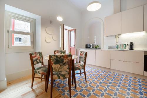 a kitchen with a table and chairs in a room at Entre Ruas Apartments in Coimbra