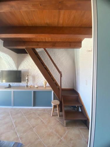 Santa-Reparata-di-BalagnaにあるA Casa di Furtunatuのテーブルと椅子が備わる客室内の階段