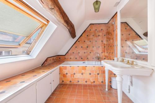 une salle de bain avec un lavabo et une fenêtre dans l'établissement Renaissance, à Paris