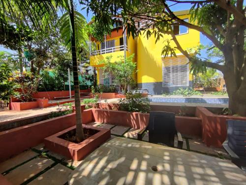 a table and chair under a tree in front of a building at Redstone House by Oxystays Hospitality in Ganpatipule