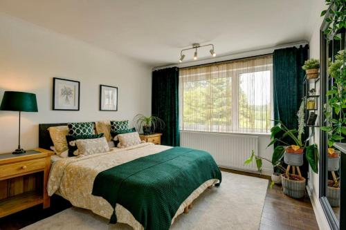 a bedroom with a bed with a green blanket at Pippins in Tiverton