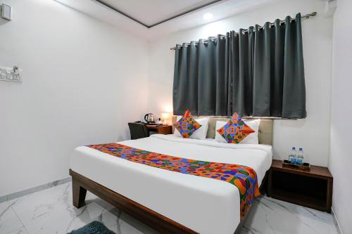 1 dormitorio con 2 camas y ventana en FabHotel Fortuna Inn en Navi Mumbai