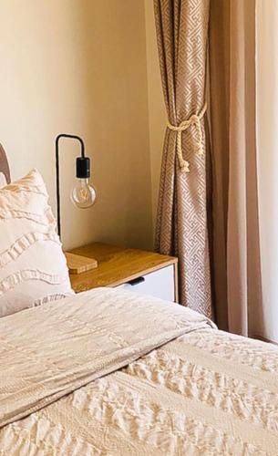 a bedroom with a bed and a table with a lamp at 4 bedroom family home in Riverwood in Riverwood