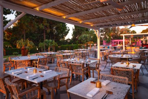 una zona de comedor al aire libre con mesas y sillas en Boho Club en Marbella