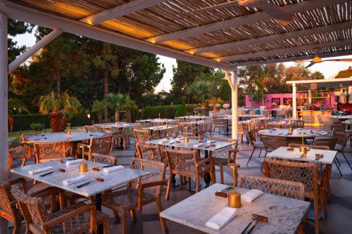 una zona de comedor al aire libre con mesas y sillas en Boho Club, en Marbella