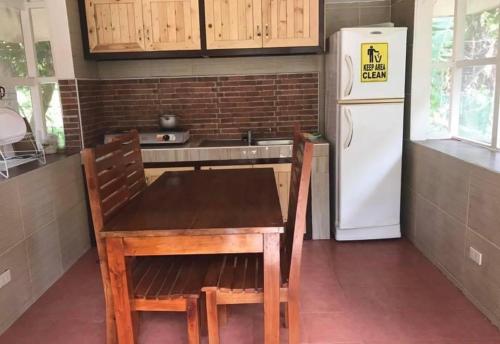 a kitchen with a wooden table and a white refrigerator at Relova’s Orchard Place in Victoria