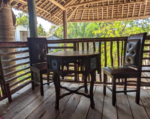 - une table et deux chaises sur une terrasse couverte dans l'établissement Cocobongo Beach Lodge, à Dar es Salaam
