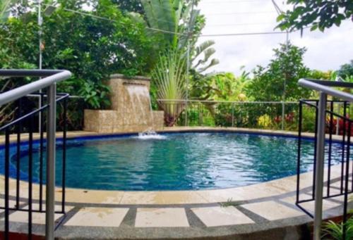 a swimming pool in a garden with a fountain at Relova’s Orchard Place in Victoria