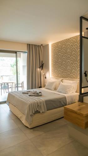 a bedroom with a large bed and a balcony at Alissachni SeaSide Hotel in Derveni