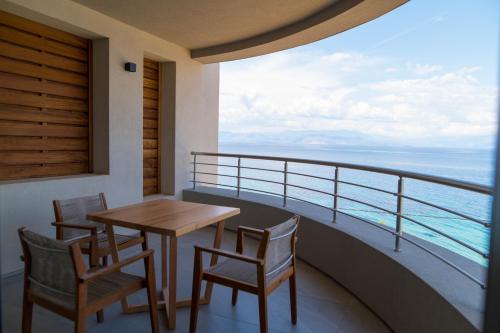 a balcony with a table and chairs and the ocean at Alissachni SeaSide Hotel in Derveni
