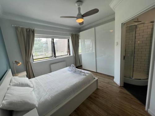 a bedroom with a bed and a bathroom with a shower at Stylish Flat With River View in Dublin