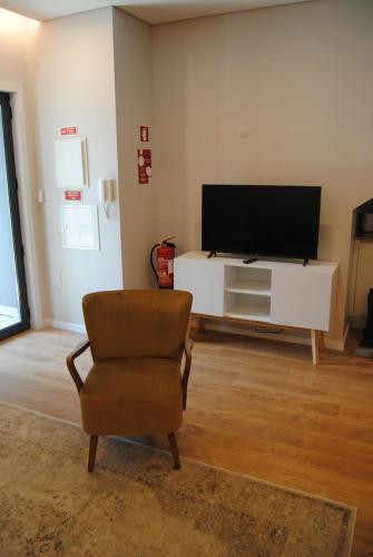 a living room with a chair and a flat screen tv at Gaia Loves You - Serra do Pilar in Vila Nova de Gaia