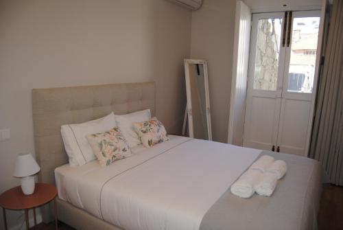 a bedroom with a large white bed with towels on it at Gaia Loves You - Serra do Pilar in Vila Nova de Gaia