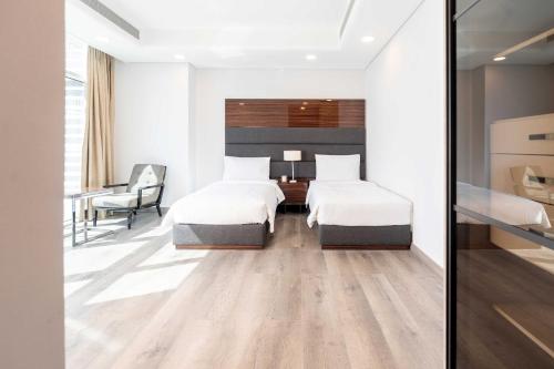 ein Hotelzimmer mit 2 Betten und einem Schreibtisch in der Unterkunft S Plaza Suites Hotel in Seef