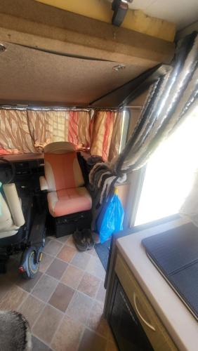 um pequeno quarto com um sofá e uma cadeira num trailer em Motorhome em Los Cristianos