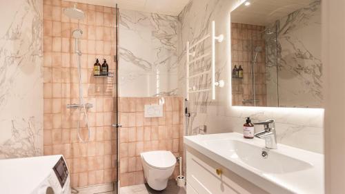 een badkamer met een douche, een wastafel en een toilet bij Villa Maija 3 Westside in Hanko