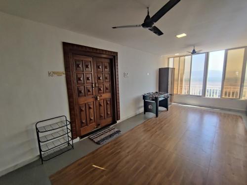 an empty room with a door and a wooden floor at WhiteHouse Homestay by Oxystays Hospitality in Alibaug