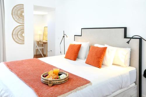 a white bed with a tray of fruit on it at Xtraordinary Moments Apartment in Faro