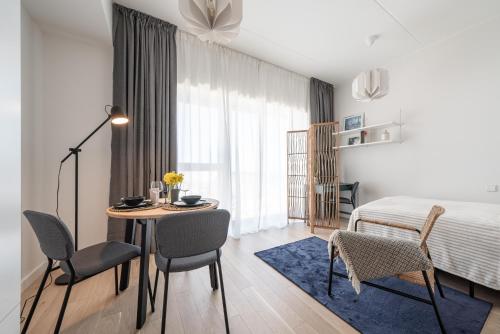 a bedroom with a bed and a table and chairs at Unique Kalaranna District Apartments by the Sea in Tallinn