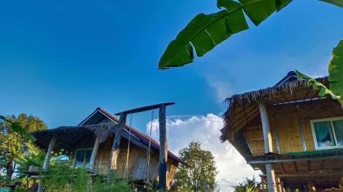 a couple of houses sitting next to each other at ไร่นิธิสุนทร nithisoonthon farmstay in Mae Hong Son