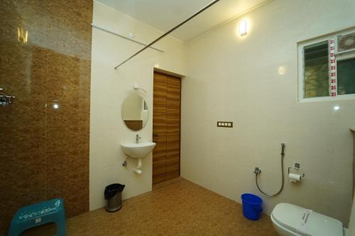 La salle de bains est pourvue de toilettes, d'un lavabo et d'un miroir. dans l'établissement Pearl bell Villa, à Pondichéry