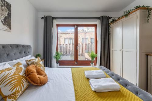 a bedroom with a large bed with a yellow blanket at The Waterloo Apartment - Large Private Patio & Air Conditioning in London