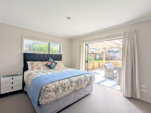 a bedroom with a bed and a sliding glass door at Make yourself Home in Rotorua