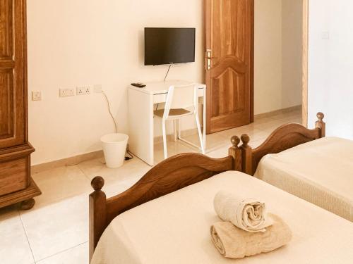 a bedroom with two beds and a desk with a television at XL Central Home - Sleeps 10 people in Pieta