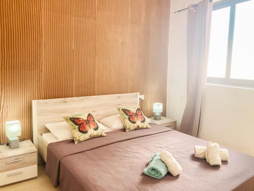 1 dormitorio con 1 cama con mariposas en las almohadas en XL Central Home - Sleeps 10 people, en Pieta