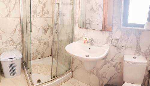 a bathroom with a shower and a sink and a toilet at XL Central Home - Sleeps 10 people in Pieta