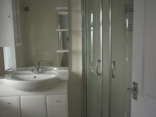韋茅斯的住宿－Bargain rooms in Weymouth，一间带水槽和玻璃淋浴的浴室