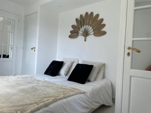 a white bedroom with a bed with black pillows at Maison d Hotes BLUE PALM Aix en PROVENCE in Aix-en-Provence