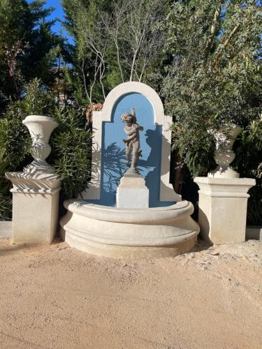 a statue in the middle of two vases at Maison d Hotes BLUE PALM Aix en PROVENCE in Aix-en-Provence