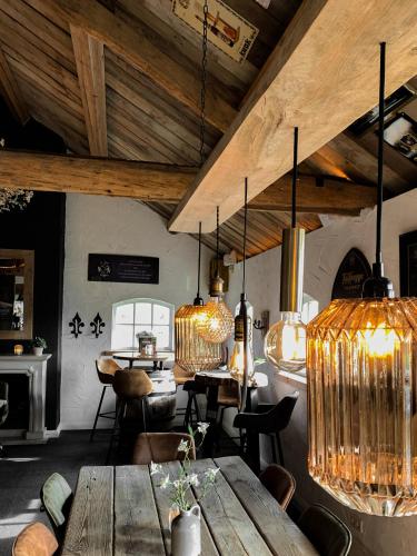 a room with tables and chairs and chandeliers at Brabantse Hoeve in Volkel