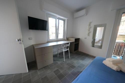 a bedroom with a desk and a bed and a window at Opuntia Charming Rooms in Taormina