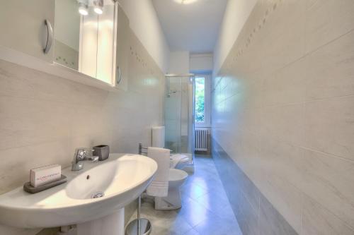 a white bathroom with a sink and a toilet at Casa Al Caprifoglio 600m From Beach - Happy Rentals in Ispra