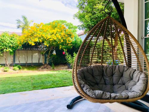 een schommelstoel op een patio met een tuin bij Ban Soi San Sook Homestay in Songkhla